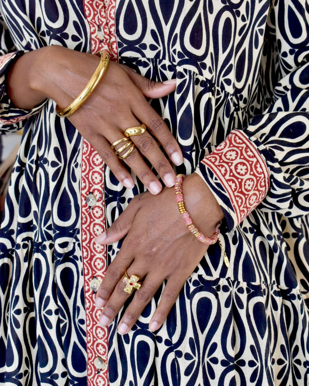 Close-up of hands with jewelry on a patterned fabric background