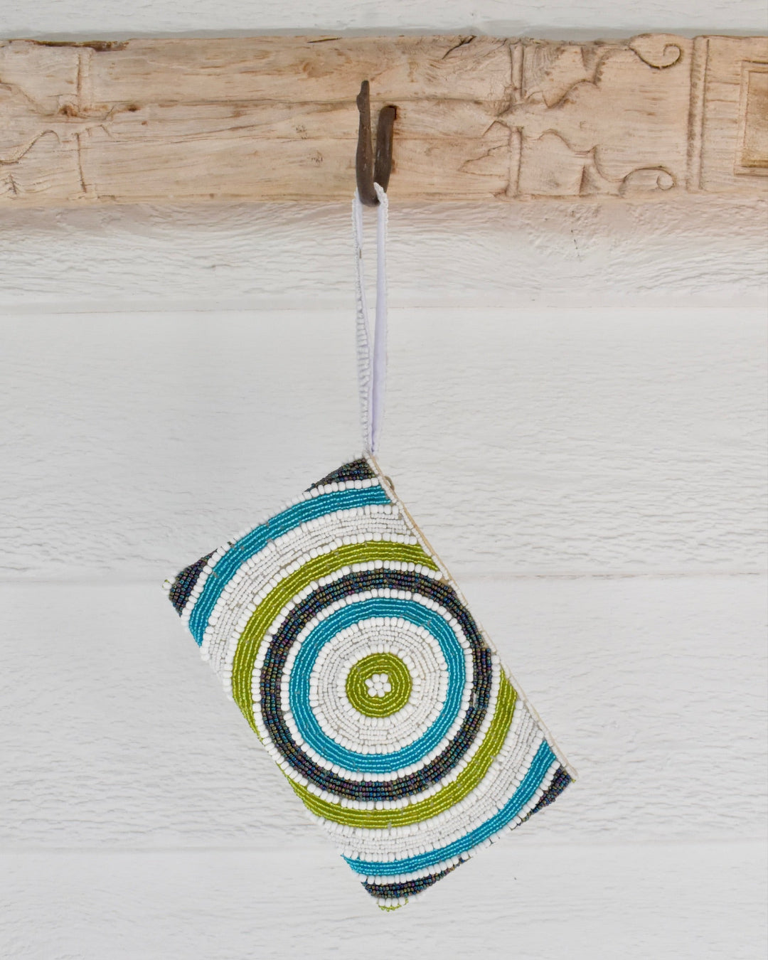 Colorful circular pouch hanging on a wooden surface