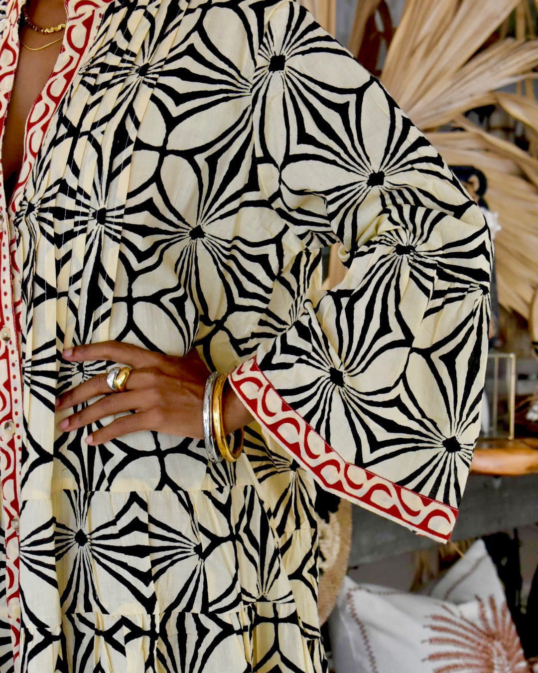 Person wearing a black and white patterned outfit with red accents.