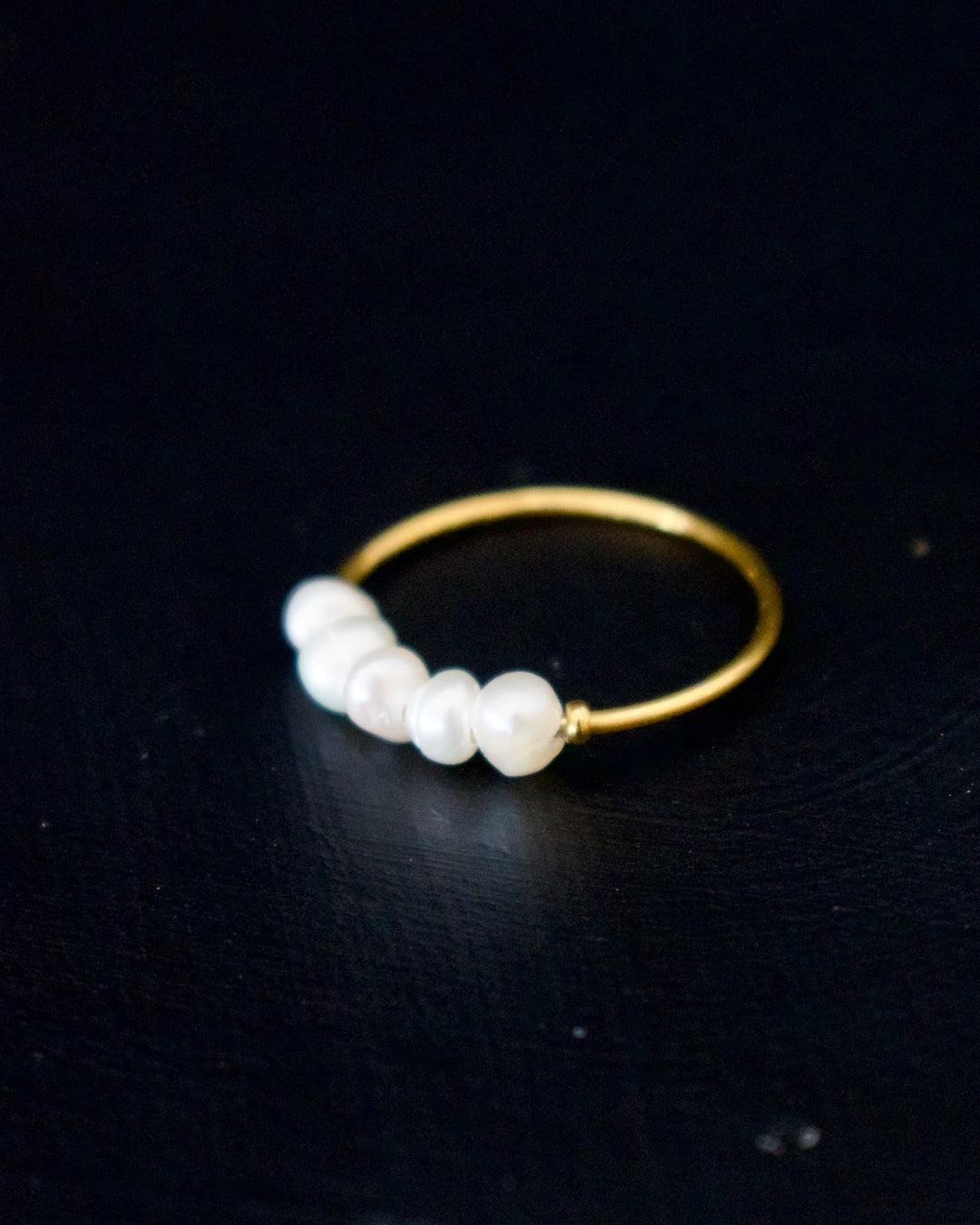 Gold ring with pearls on a black background