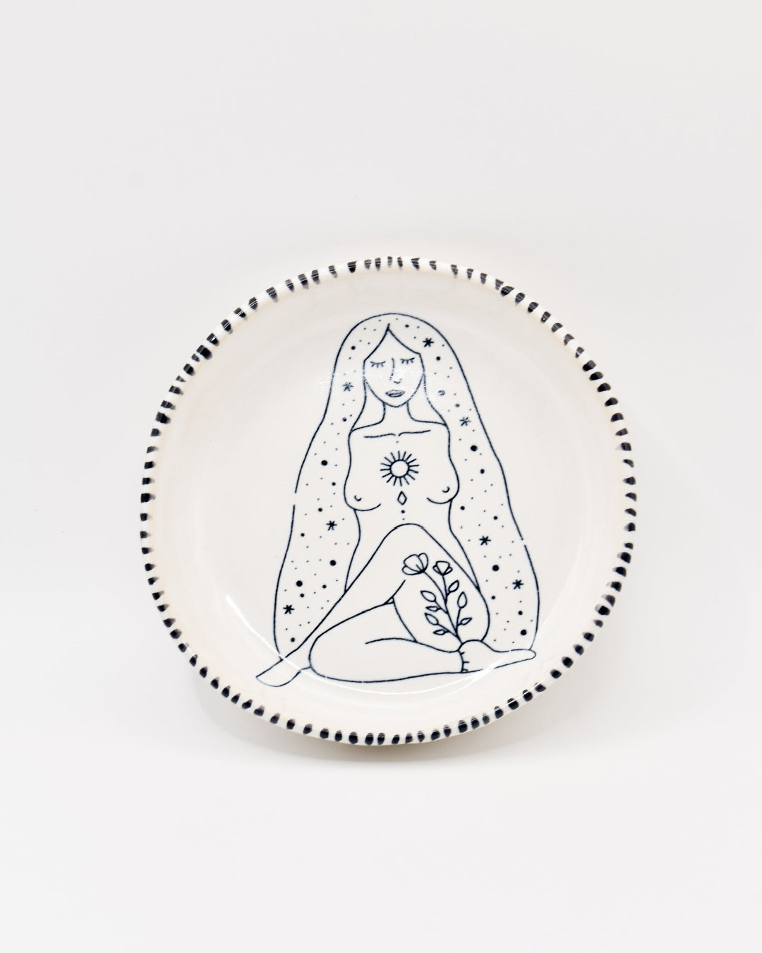 Ceramic plate with a black line drawing of a woman on a white background