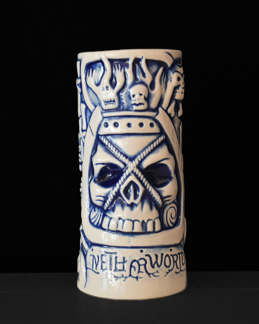 Ceramic mug with skull design and text on a black background