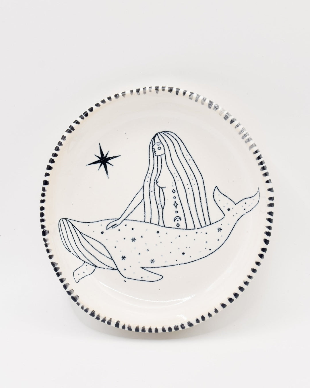 Ceramic plate with a black and white illustration of a mermaid and whale on a white background